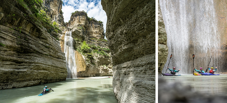 Kayakers paddling through a narrow limestone canyon as a tall waterfall spills into a pool below.
